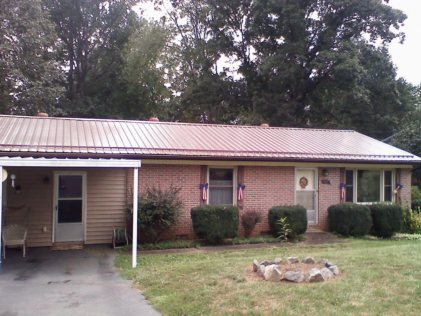 Bronze metal roof and carport on a brick ranch home — Roof Repair work by our crew in Bozman
