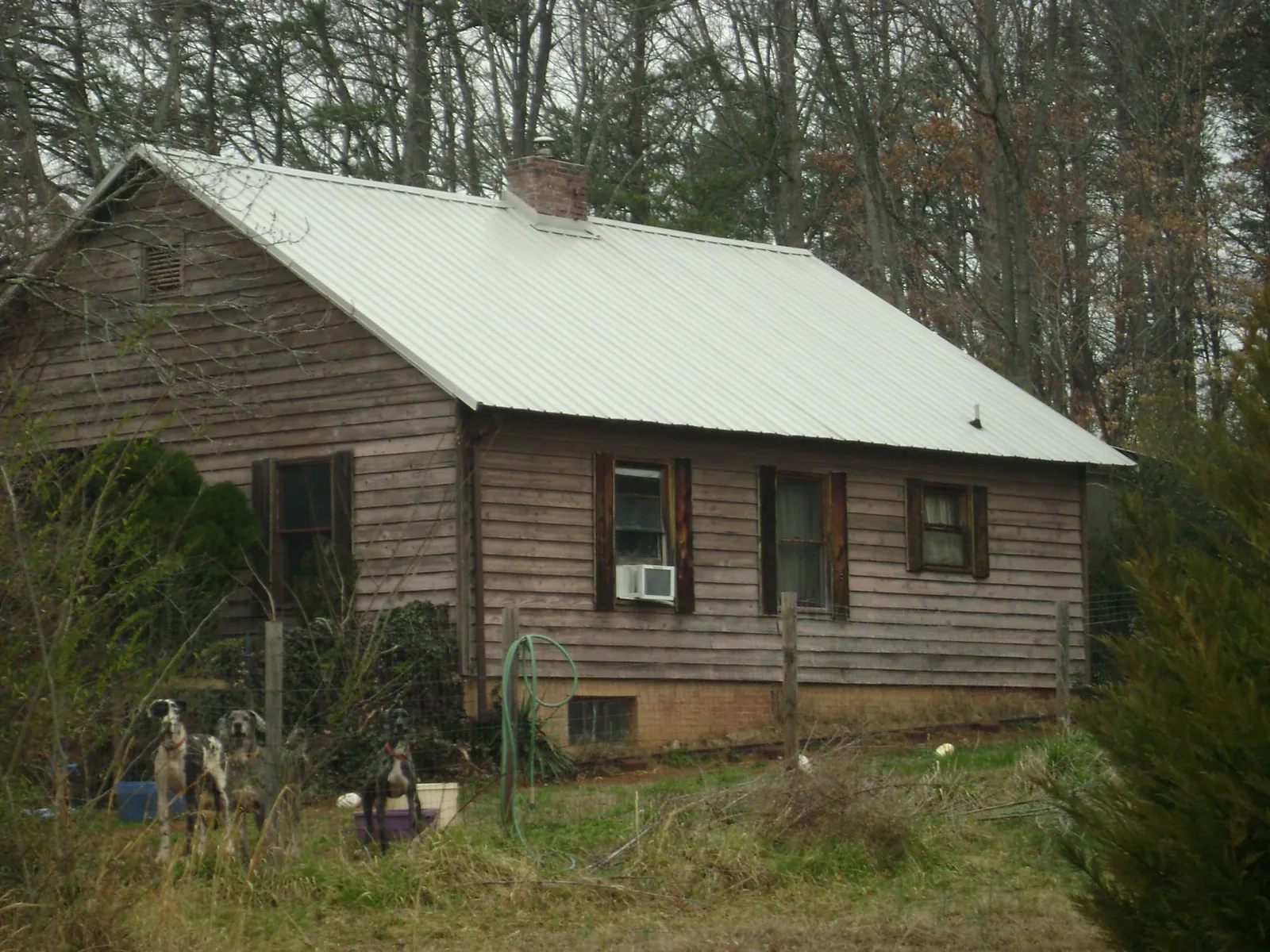 White metal roof on an old wood sided farmhouse, from a Metal Roof Installation job in Bozman